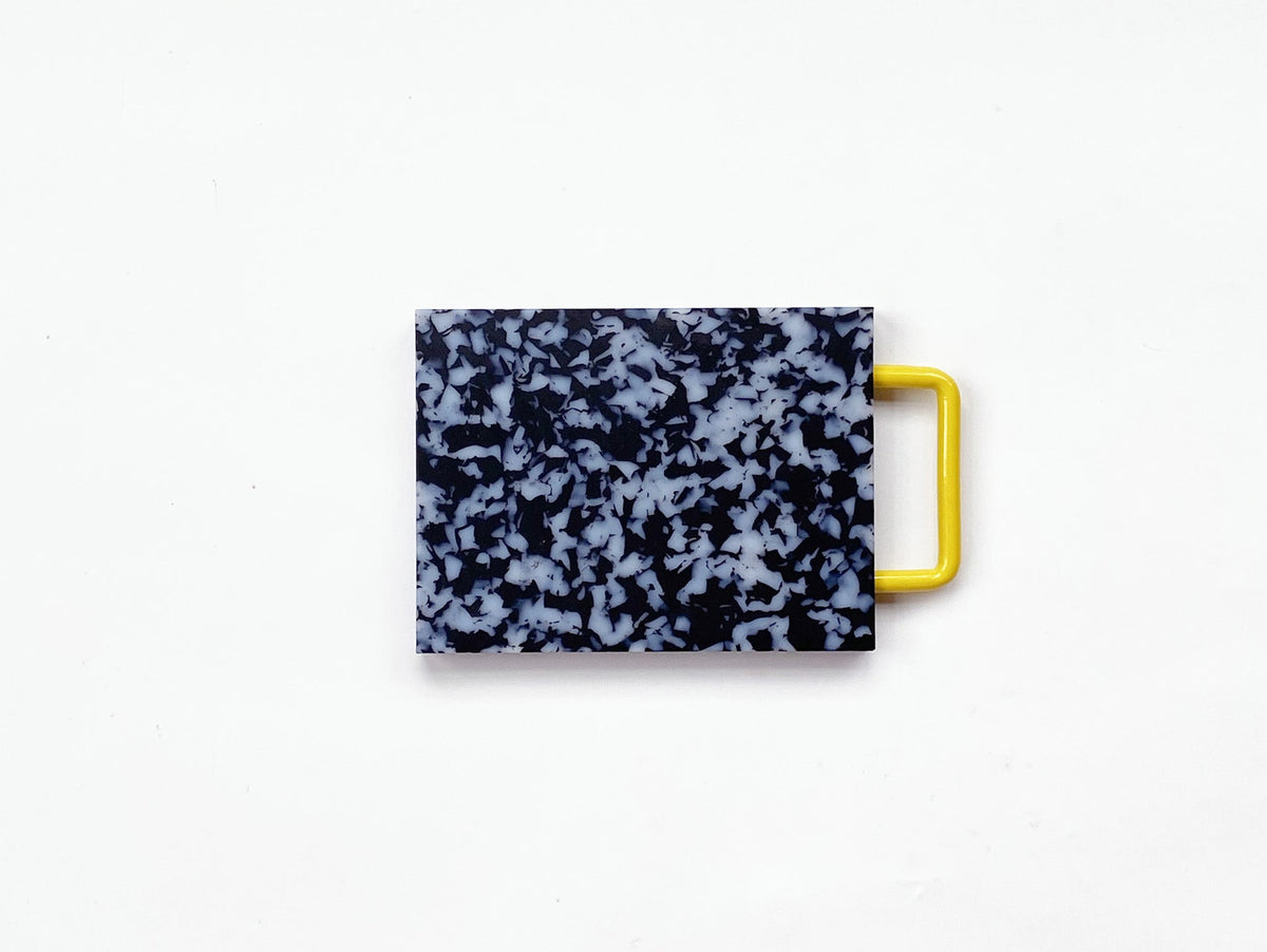 Small black and white HDPE cutting board with metal handle